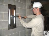 Attempting to straighten a bowed foundation wall by straightening a wall anchor system in a Alexandria home.