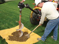 Auguring a hole in the earth for a foundation wall repair system in Alexandria