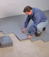 Contractors installing basement subfloor tiles and matting on a concrete basement floor in Rockville, Virginia & Maryland